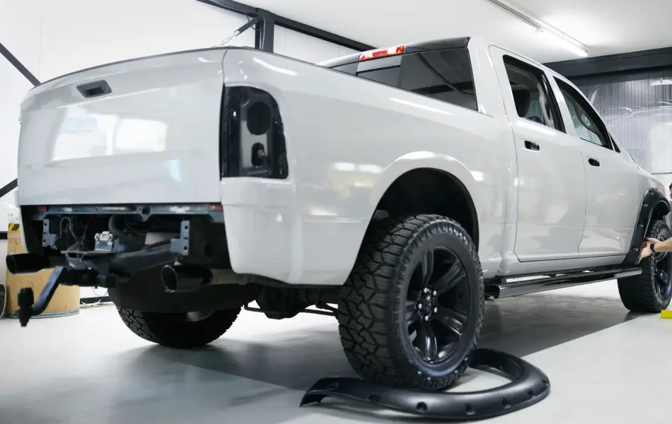 White truck in a body shop receiving expert repair services in Franklin, NC.