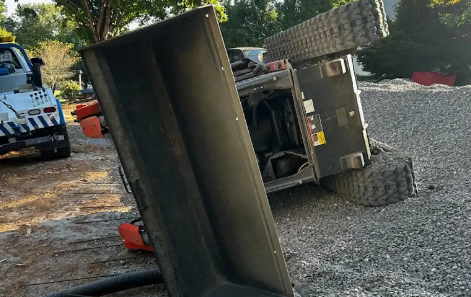 Heavy duty towing crew recovers overturned compact hauler at gravel site in Western North Carolina