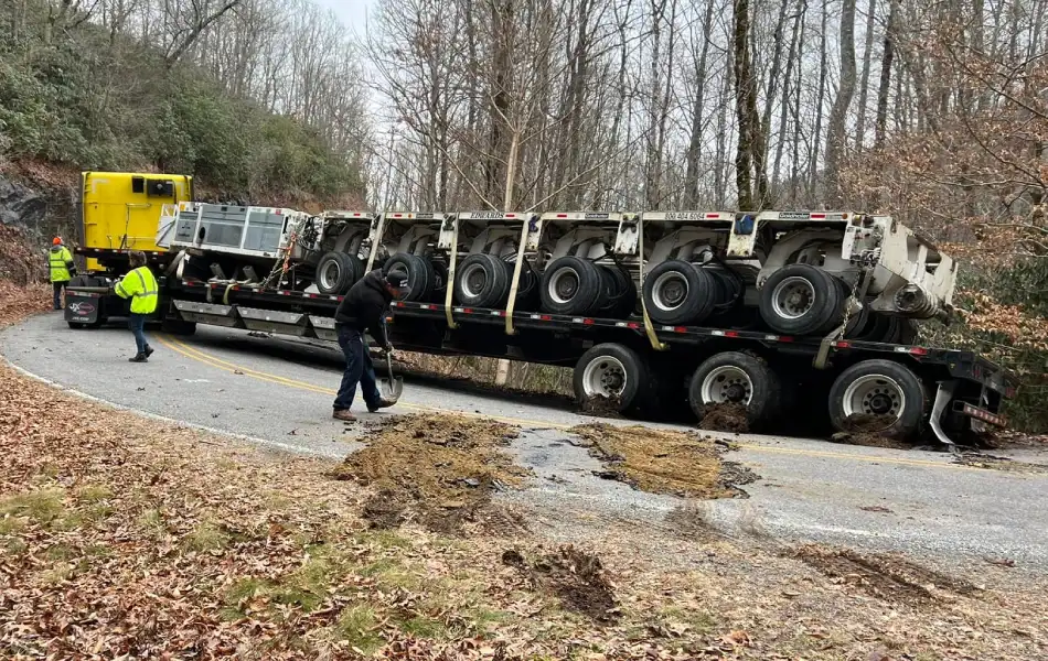 Heavy duty towing crew stabilizing a trailer on a narrow mountain road in Western North Carolina