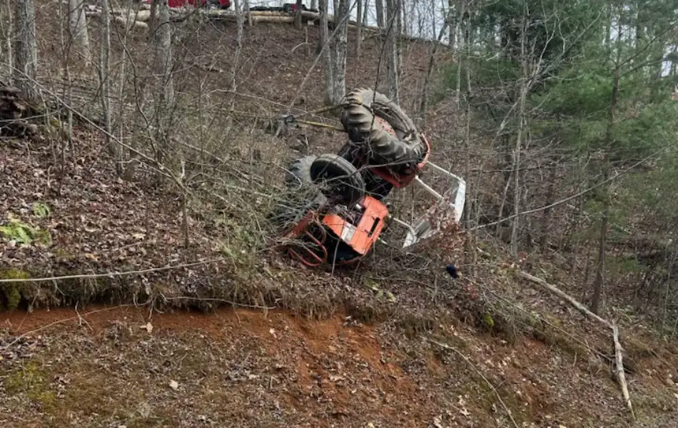 Overturned tractor recovered from steep hillside by heavy duty towing crew in Western North Carolina