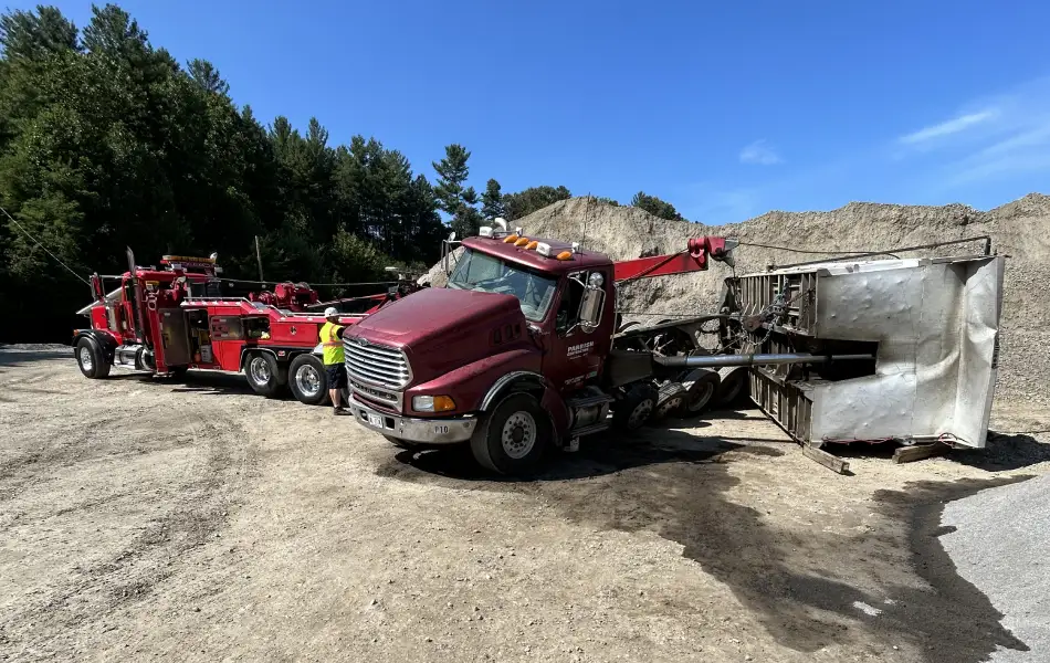 Heavy duty towing crew uprights overturned trailer at a gravel site in Western North Carolina